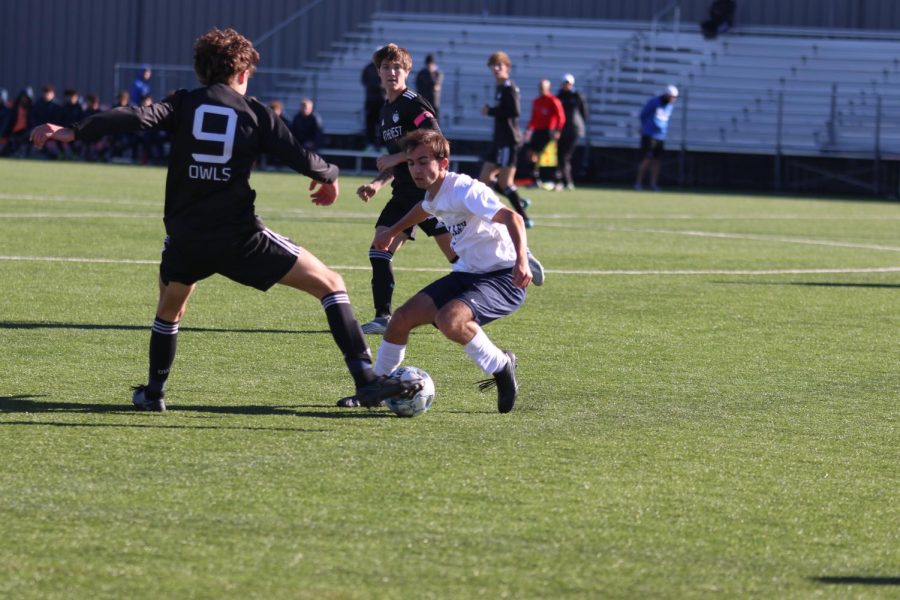 Running up to the opposing player, senior Jack Gilmore takes the ball back.