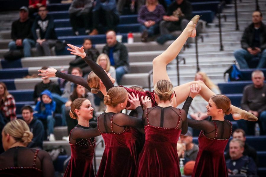 Lifting up one of their dancers, the Silver Stars perform their competition piece at half time.