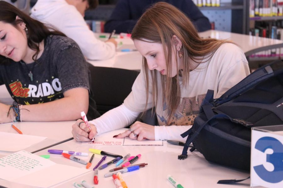 Writing a letter, senior Paige Dinslage focuses on her Christmas card.