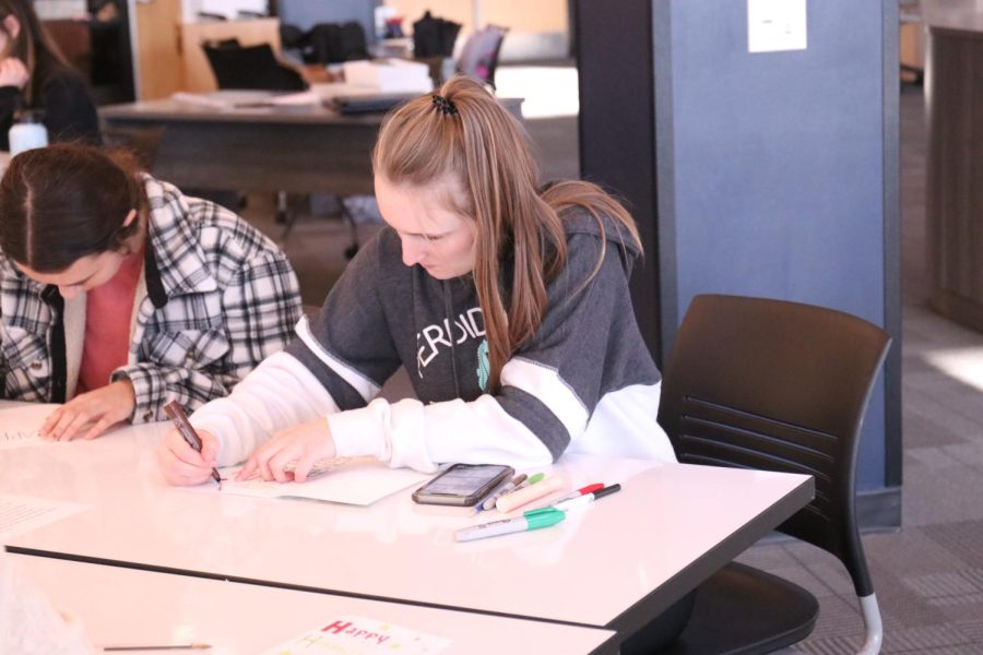Decorating the inside of her card, senior Jayda DeWitte concentrates on her drawing. 