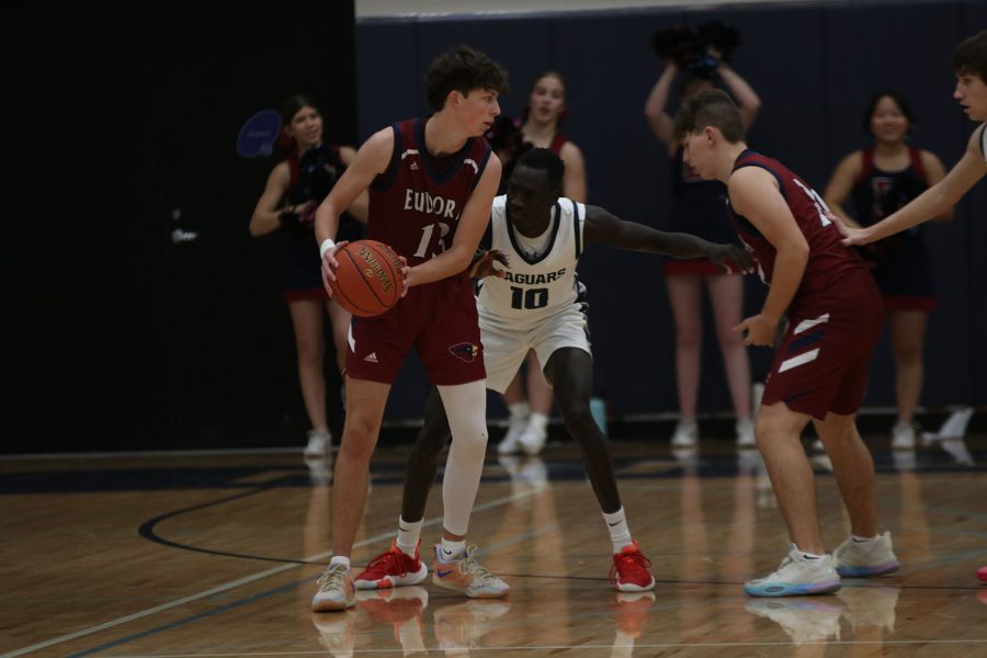 With his eye on the ball, senior Nen Matlock defends his man. 
