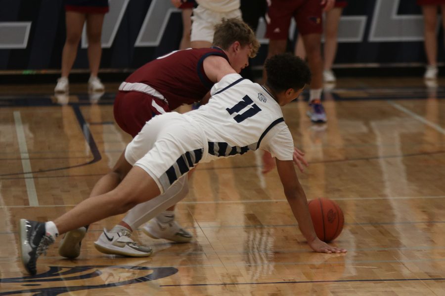 Diving for the ball, senior Jameson Fisher attempts to get a steal. 
