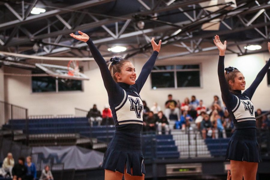 Junior Madeline Epperson and senior Sidney Claeys face the crowd to cheer for Jaguars during a timeout. 