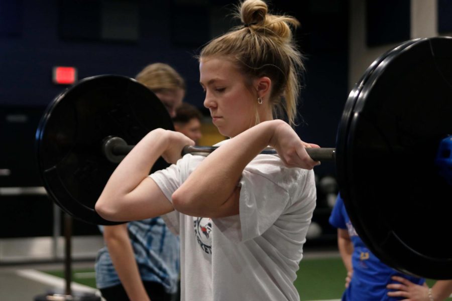 Looking down, freshman Callie Caldwell pulls the bar close to her chin. 