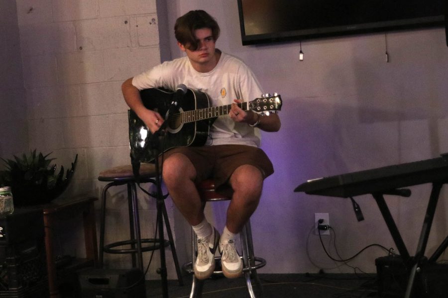 Senior Atticus O’brien performs alongside his guitar.