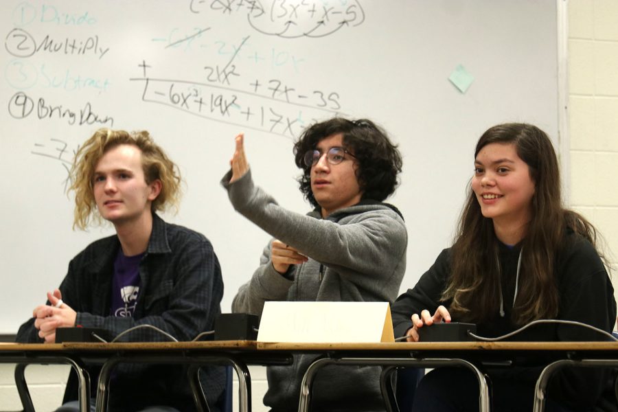 Discussing a difficult geometry question, junior Evan Mack and senior Avery Gathright watch as sophomore Yazid Vazquez visualizes the problem.