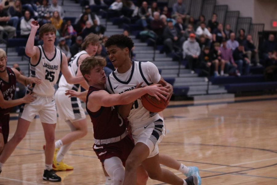 Senior Jameson Fisher protects the ball from his opponent trying to make a basket. 