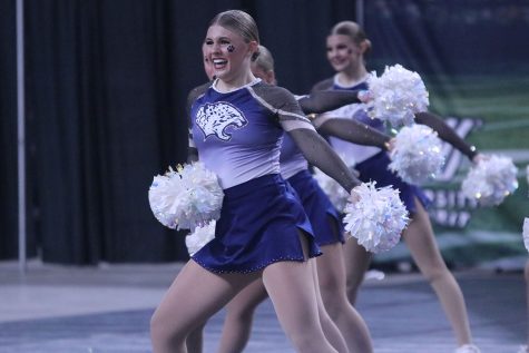 Moving across the floor, junior Halle Wampler smiles as she performs at the Kansas state dance competition. 
