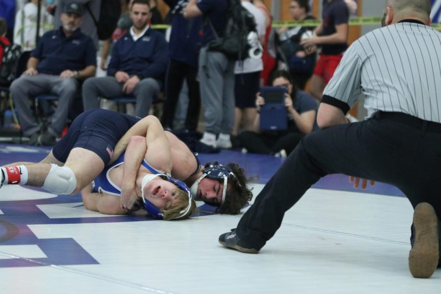 With the referee counting, junior Maddox Casella pins his opponent and wins the match.