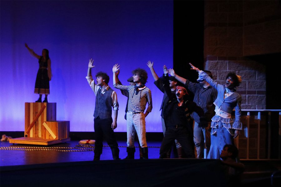 Seniors Carter Harvey and Sean Olin are surrounded by their fellow cast members, as all actors present during this scene wave looking across the stage in unified song Tuesday, Dec. 6.  