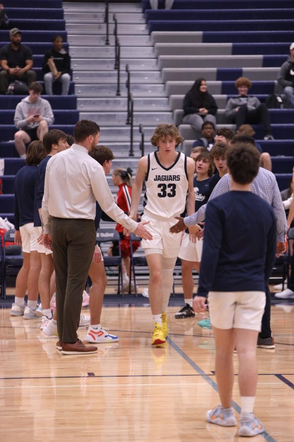 Junior Mason Kemp makes his way through the high-five line during pregame intros.