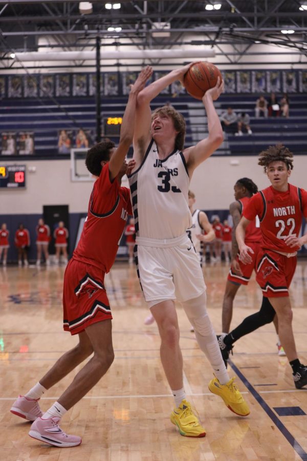 Reaching up for a layup, junior Mason Kemp fights through a defender.