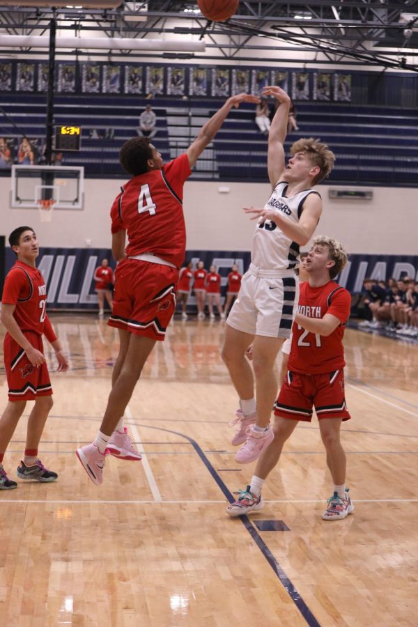 Attempting a fade-away shot, junior Bryant Wiltse throws the ball over the defender. 