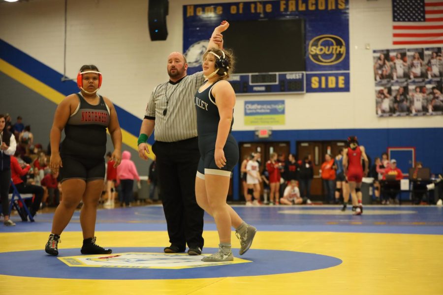 After winning a match, freshman Emma Lee raises her hand.