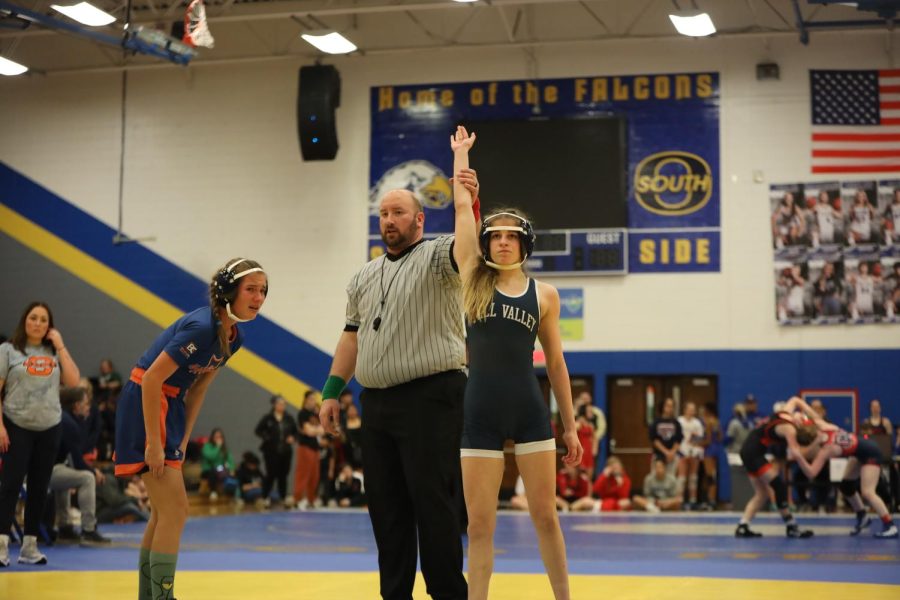 Holding her hand high, freshman Finley Rose determinedly looks into the crowd.