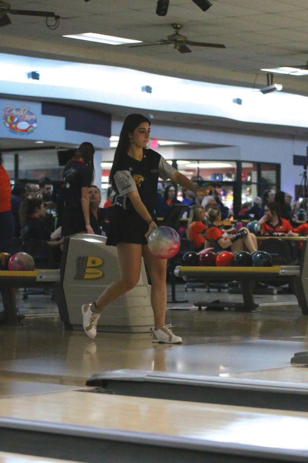 Approaching the beginning of the lane, freshman Ava Edwards prepares to roll the bowling ball toward the pins.