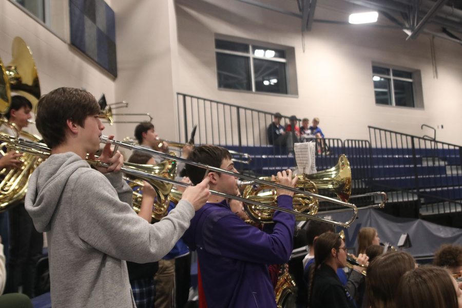 Focused on his playing, senior Colin Scherzer plays the trombone next to senior Tyler Larson on the baritone. 