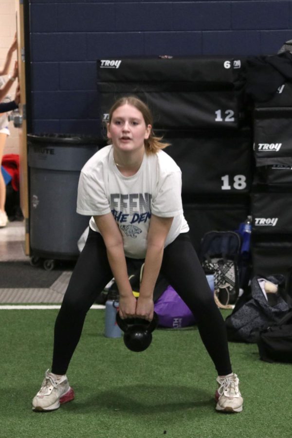 Junior Kate Marten swings the kettlebell between her legs.