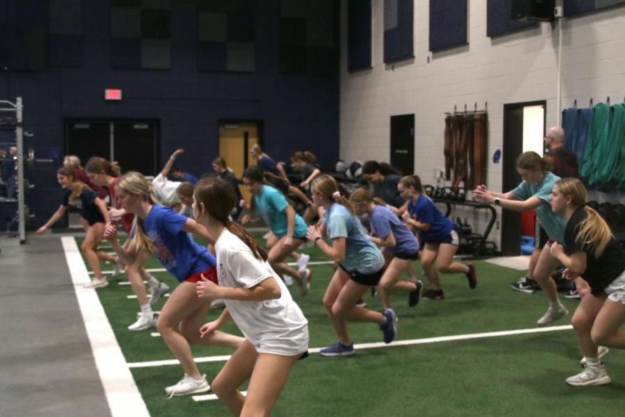 The soccer winter workout program members jump back and forth.