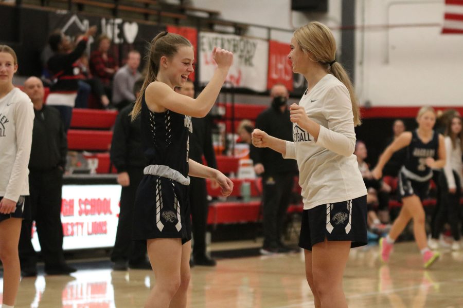 With big smiles, sophomores Josie Benson and Marissa Hoelting perform their pregame handshake. 