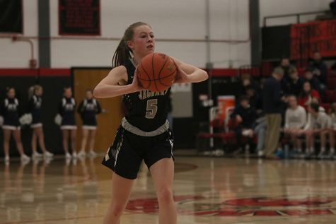 Eyes up the court, sophomore Josie Benson passes the ball. 