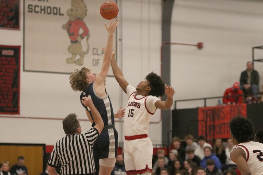 Jumping high, junior Mason Kemp competes for the opening tip. 
