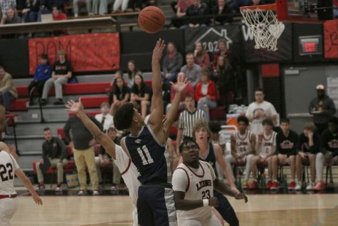 Finishing high, senior Jameson Fisher attempts to float the ball into the hoop. 
