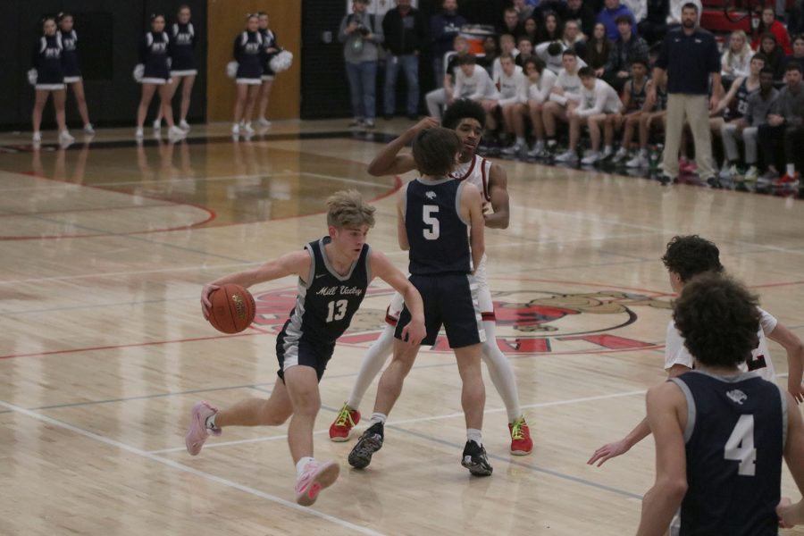 Eyes towards the lane, junior Bryant Wiltse dribbles off the screen set by junior Kael Drummond. 
