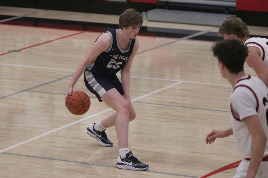 With concentration, sophomore Carter Kaifes dribbles between his legs. 
