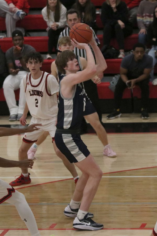 Surrounded by the opponent, sophomore Carter Kaifes shoots the ball. 
