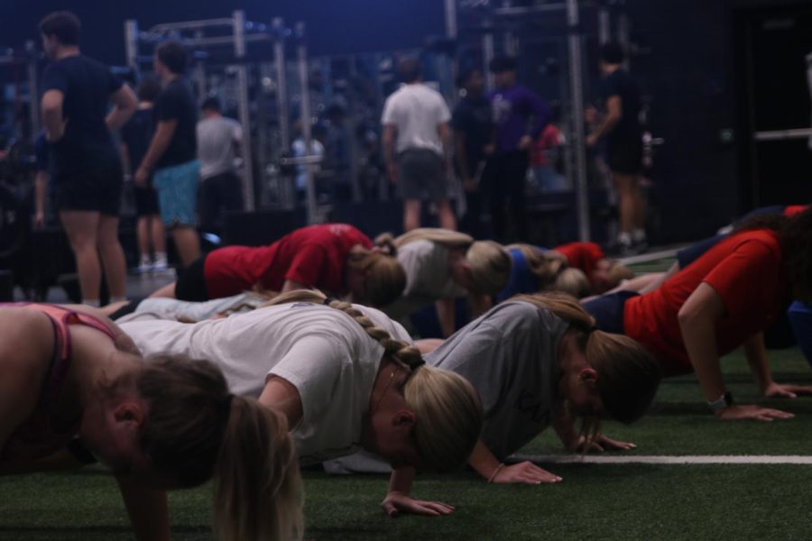 Staring at the ground, the girls focus on the workout they are doing.
