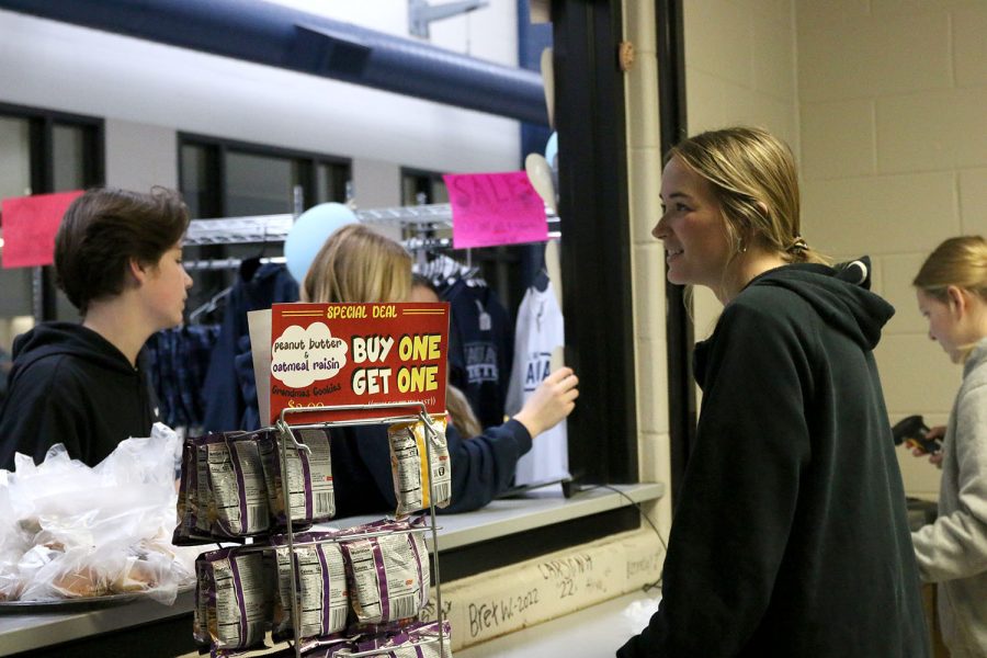 Smiling at student-customers, senior Libby Strathman works The Catty Shack during the school store’s weekly “Warm Cookie Tuesday” event. 