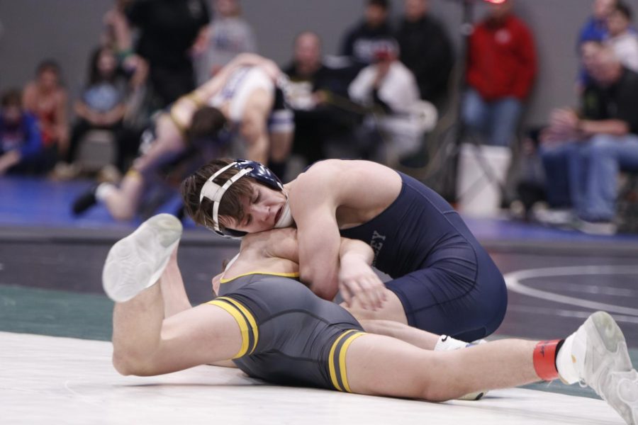 Holding his opponent down, junior Dillon Cooper wins his match.