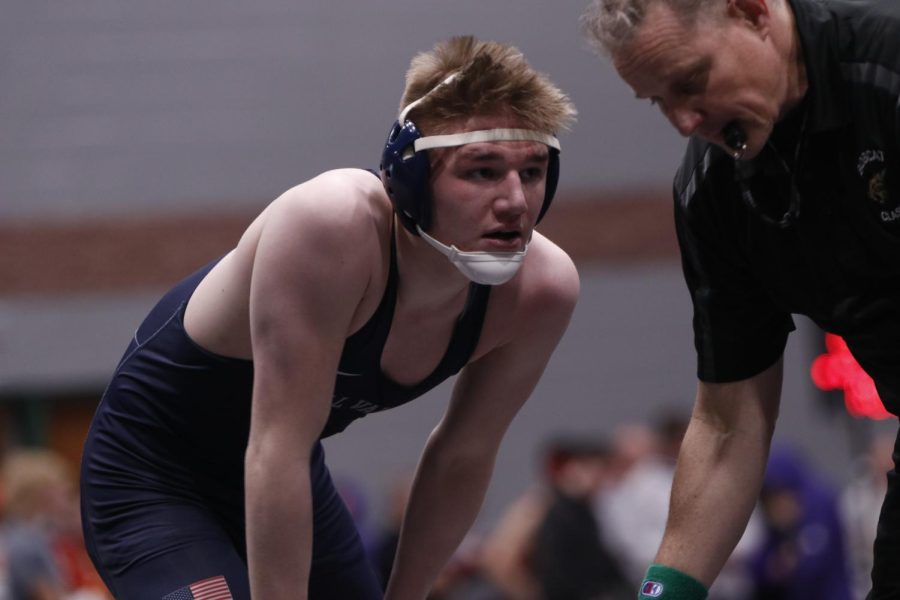 Senior Sam Imes leans down to catch his breath during his match.