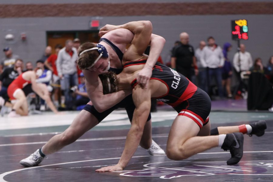 Pulling his opponent down, senior Sam Imes givies his all to win the match against his opponent. 