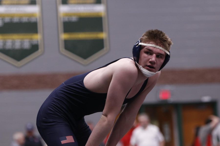 Leaning down to take a breathe, senior Sam Imes wins his match at Basehor-Linwood High school. 