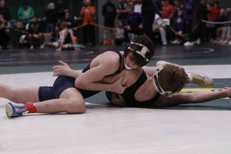 Taking the win, junior Dillon Cooper pins his opponent with 30 seconds on the clock.