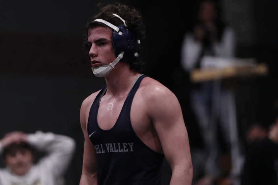 Patiently waiting for the match to start, junior Maddox Casella warms up.