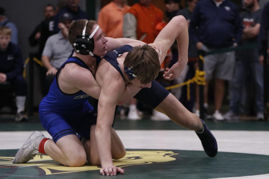 Trying to get out of the position he is in, junior Colin McAlister is eager to win his match against his opponent. 