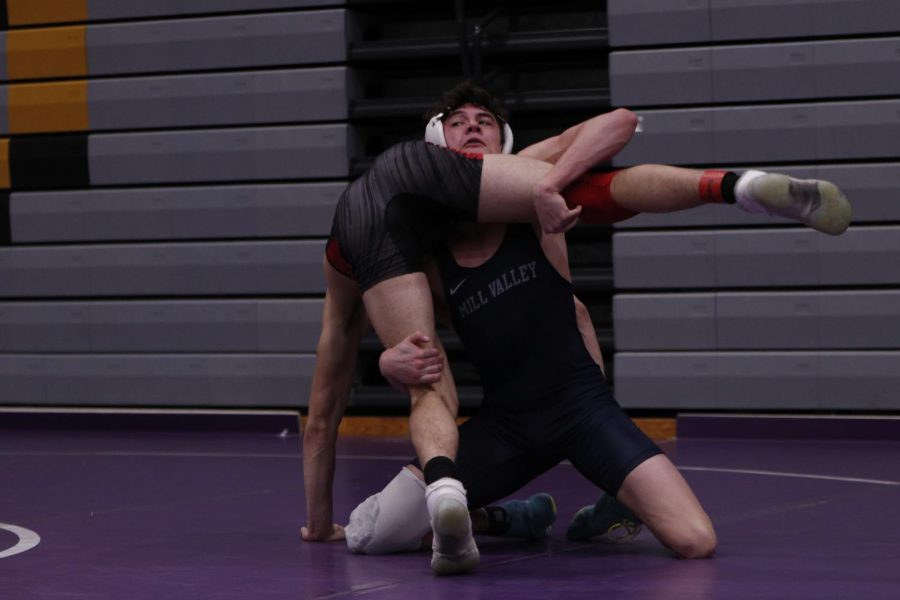 Throwing his opponent over his shoulder, senior Dylan Massey uses all his might to win.