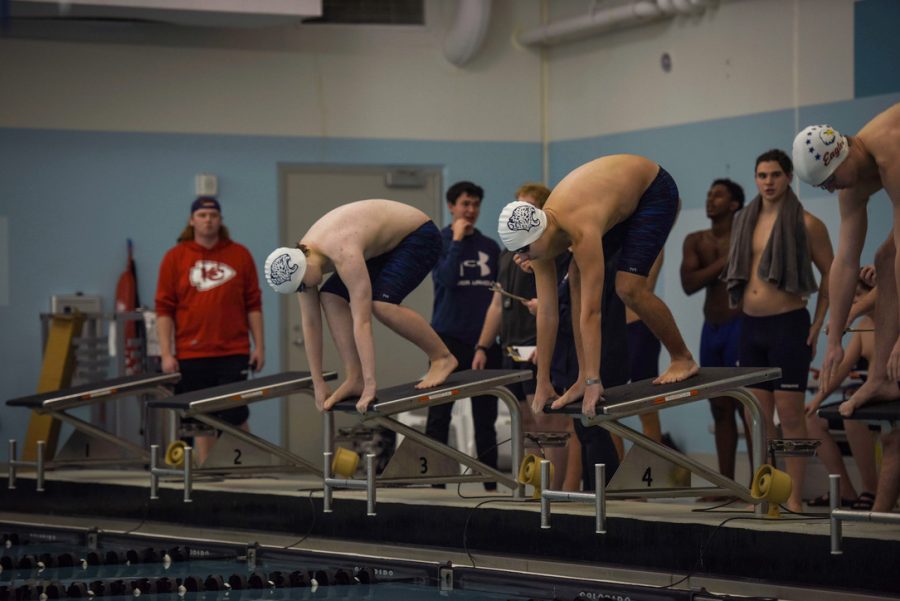 On the starting block, freshman Harrison Guest and sophomore Justice Bussell prepare to start the upcoming 100-yard freestyle Wednesday, Jan. 11.