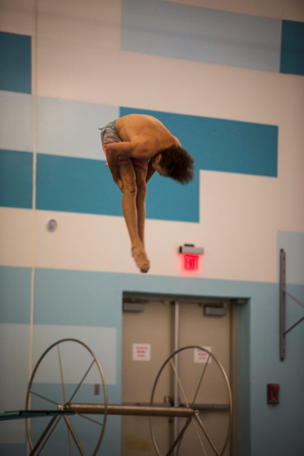 Diving into the pool, junior Max Roh grabs his legs to flip.