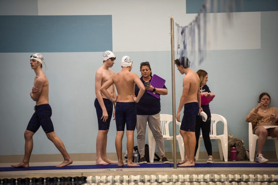 After diving, a few of the swim members discuss with swim coach Sarah Evans before the final heats of the meet.