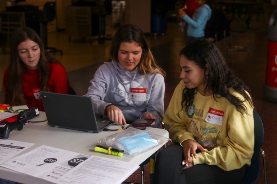 Sophomore Kenzie Johnson completes the check in process for the Red Cross blood drive with sophomores Brynn Shideler and Brooklyn Markovich Saturday Jan. 28.