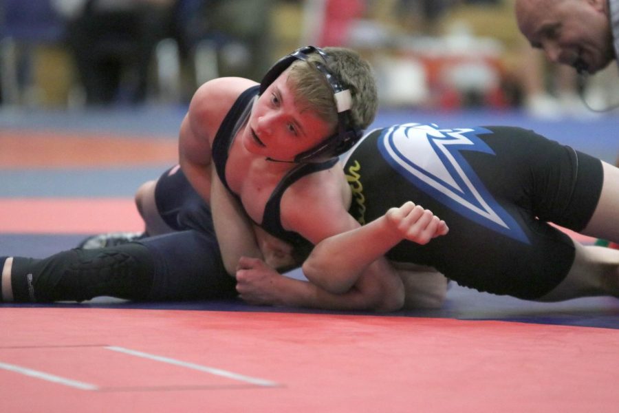 Restricting his opponents arms, freshman Jeredy Nilges pins opponent on the ground.