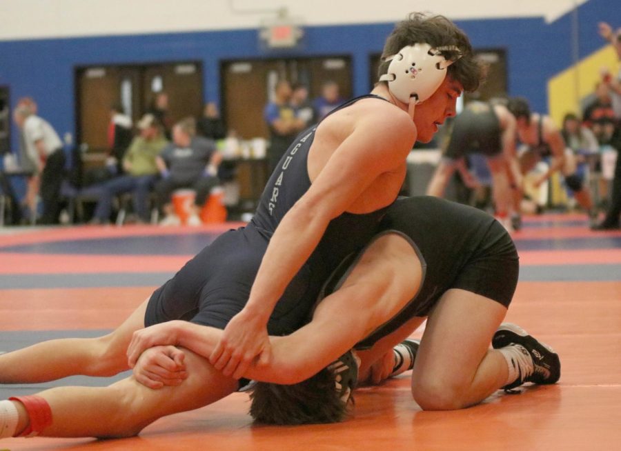 On top of his opponent, senior Dylan Massey tries escaping his opponents grip.