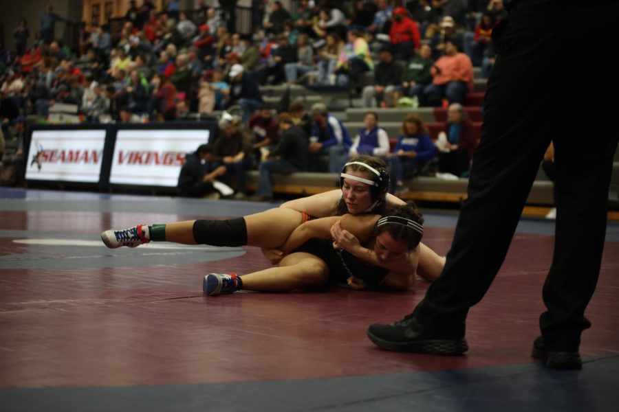 On the mat, sophomore Piper Wendler attempts to win her bout.