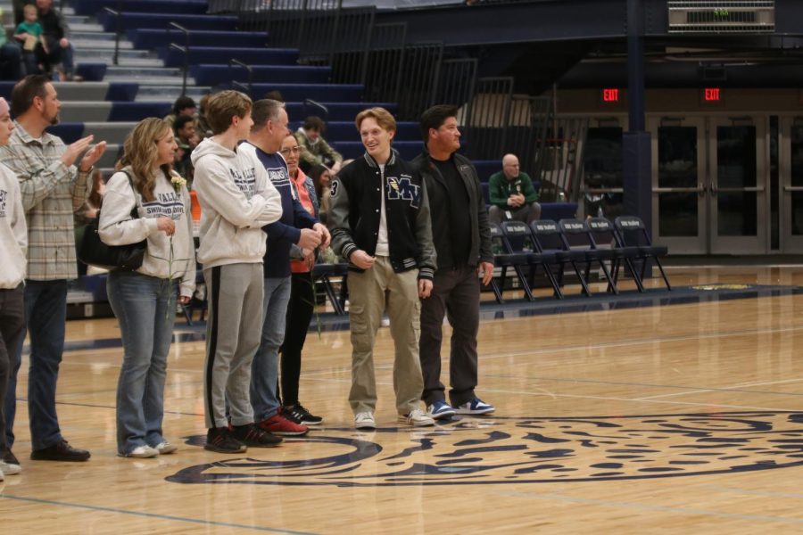 Smiling at senior Dylan Miller, senior Anthony Molinaro is recognized as a swim senior.