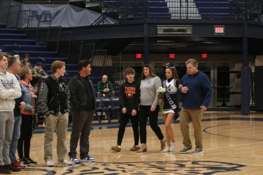 With her family, senior Sidney Claeys makes her way to the center of the court to be recognized.