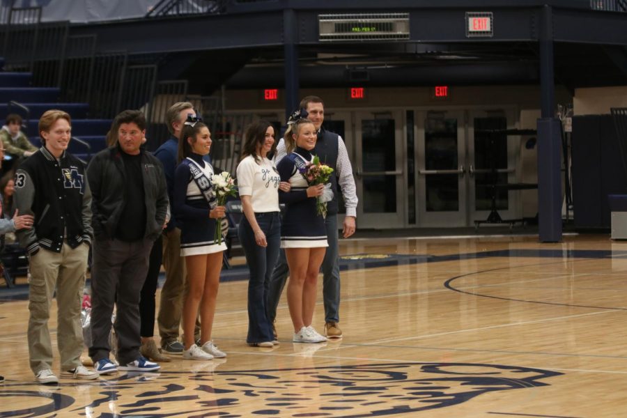 Carrying a bouquet of flowers, senior Dylan Dedrickson smiles at the crowd.